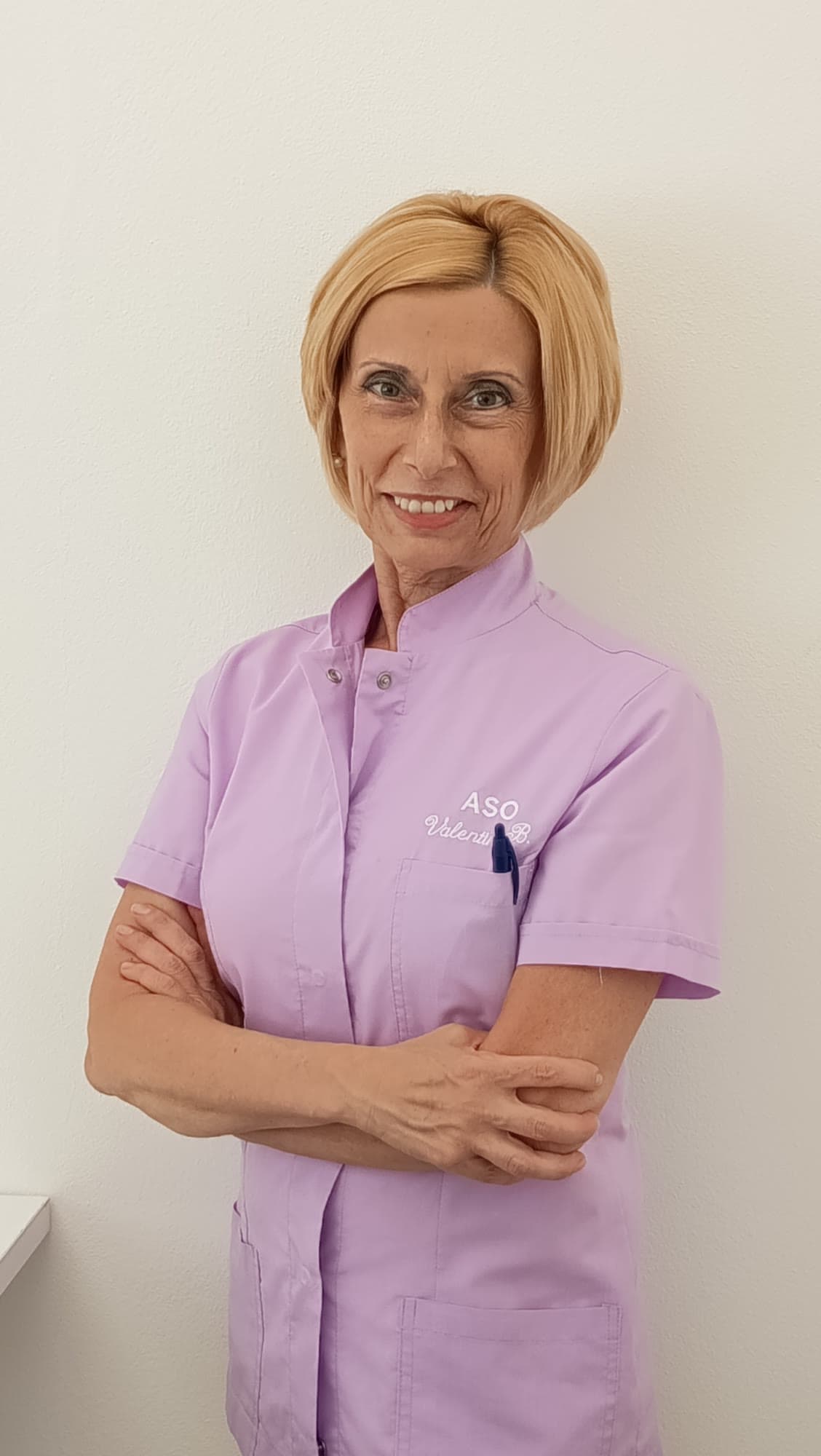 Valentina Bianchi in divisa da assistente di studio odontoiatrico, braccia conserte